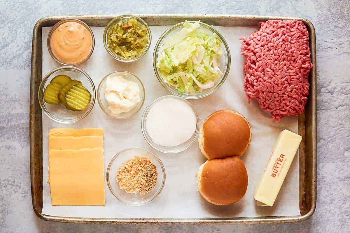 Ground chuck, American cheese slices, pickles, lettuce, onions, slider buns, and butter.