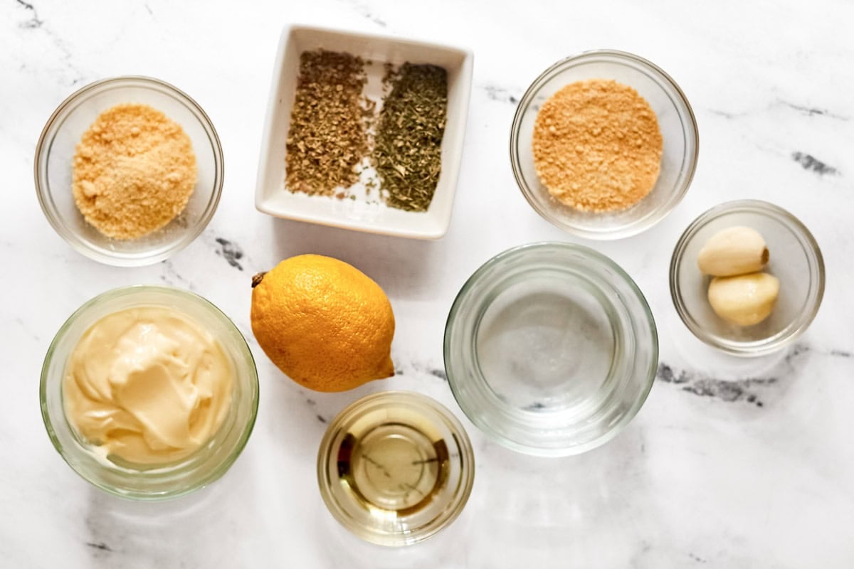 Mayonnaise, vinegar, oil, cheeses, lemon, garlic, and seasonings.