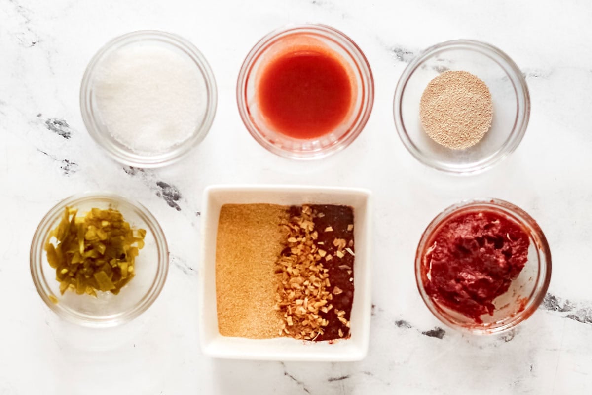 Tomato paste, vinegar, hot sauce, jalapeno, and seasonings.