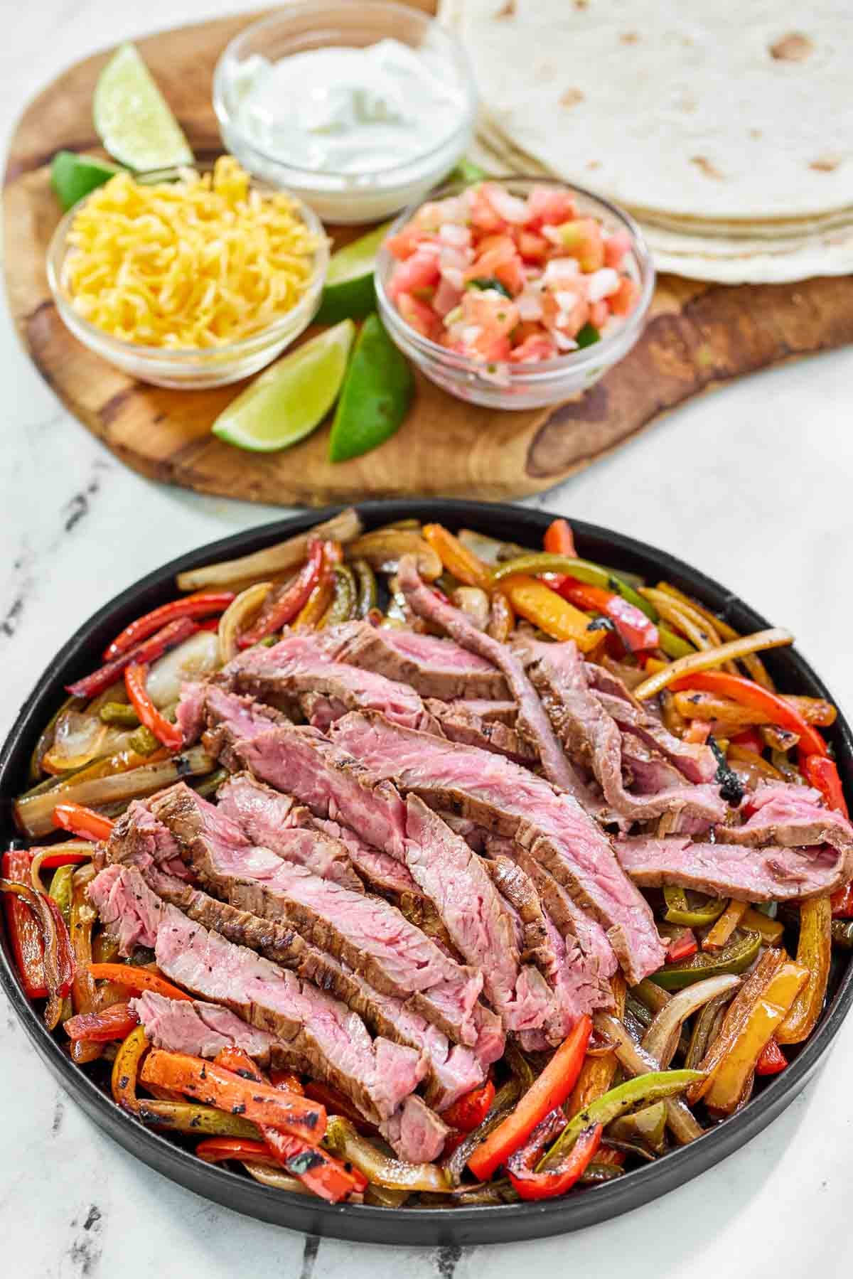 Tortillas, cheese, pico de gallo, sour cream, cheese, and grilled steak and veggies.