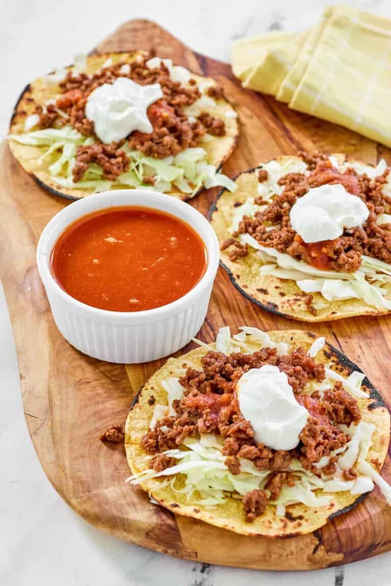 Tostadas and a small bowl of jalapeno tomato hot sauce.