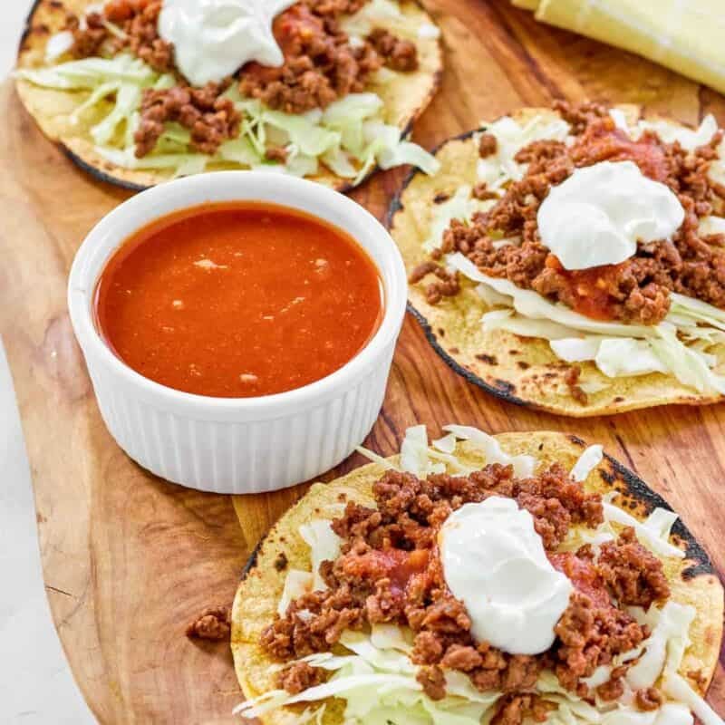Tostadas and a small bowl of jalapeno tomato hot sauce.