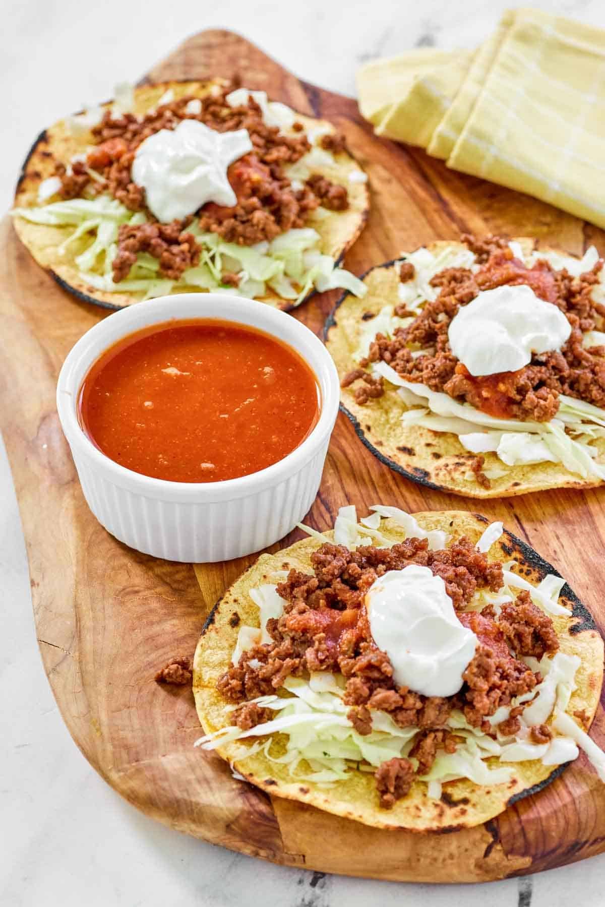 Tostadas and a small bowl of jalapeno tomato hot sauce.
