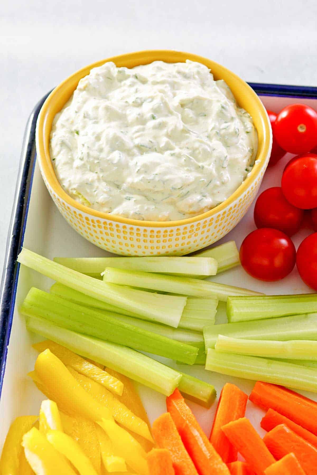 Vegetables and creamy herb dip on a tray.