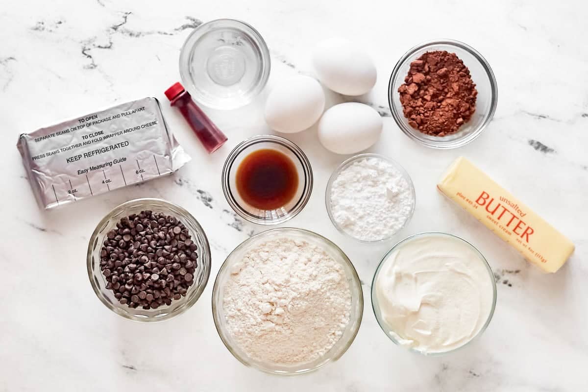 White cake mix, cocoa powder, red food coloring, butter, cream cheese, eggs, and vanilla.
