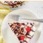 No-bake banana split pie slice and a fork on a dessert plate.