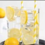 Two glasses of homemade and a lemon on a small tray.
