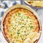 Baked onion dip with cheese in a ceramic dish.