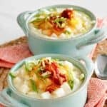 Copycat Houlihan's baked potato soup garnished with cheese, bacon, and green onions.
