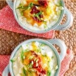 Two bowls of copycat Houlihan's baked potato soup on a braided mat.