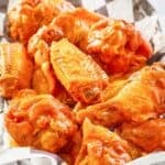 Homemade Louisiana hot sauce wings piled in a serving basket.