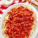 Copycat Olive Garden Bolognese sauce on top of spaghetti on a platter.