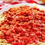 Copycat Olive Garden Bolognese sauce over pasta on a platter.