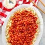 Copycat Olive Garden Bolognese served over spaghetti on a platter.