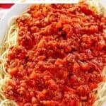 Copycat Olive Garden Bolognese sauce over spaghetti on a platter.