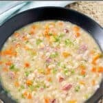 Copycat US senate navy bean soup served in a large bowl on a braided placemat.