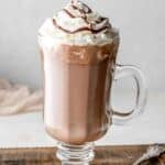 Copycat Starbucks hot chocolate in a glass mug and a spoon next to it.