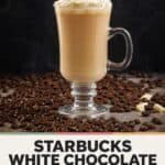 Copycat Starbucks white chocolate mocha in a glass mug surrounded with coffee beans.