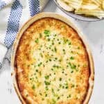 Hot and cheesy dip with onion served with potato chips.