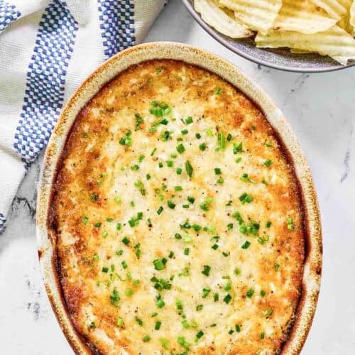Hot and cheesy dip with onion served with potato chips.