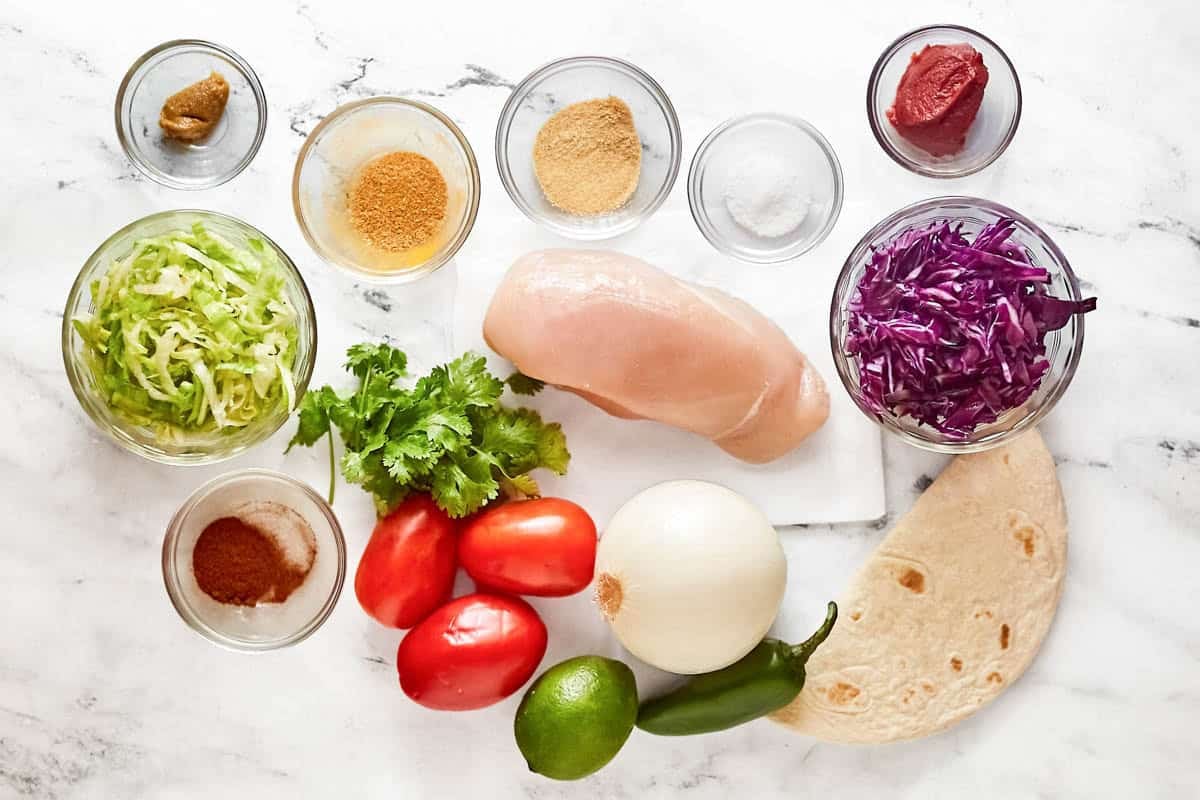 Chicken breast, flour tortillas, lettuce, tomatoes, jalapeño pepper, onion, and seasonings.