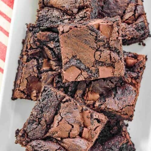 Chocolate chunk fudgy brownies on a platter.
