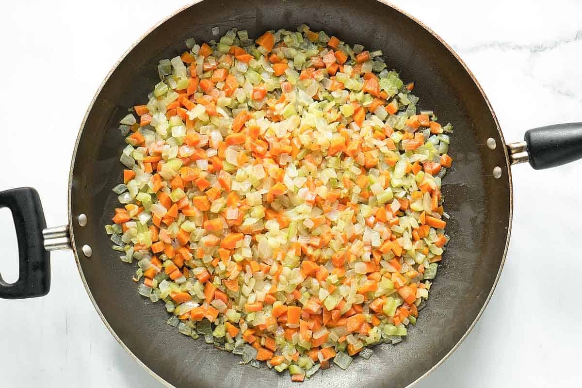 Cooking diced vegetables in a skillet.