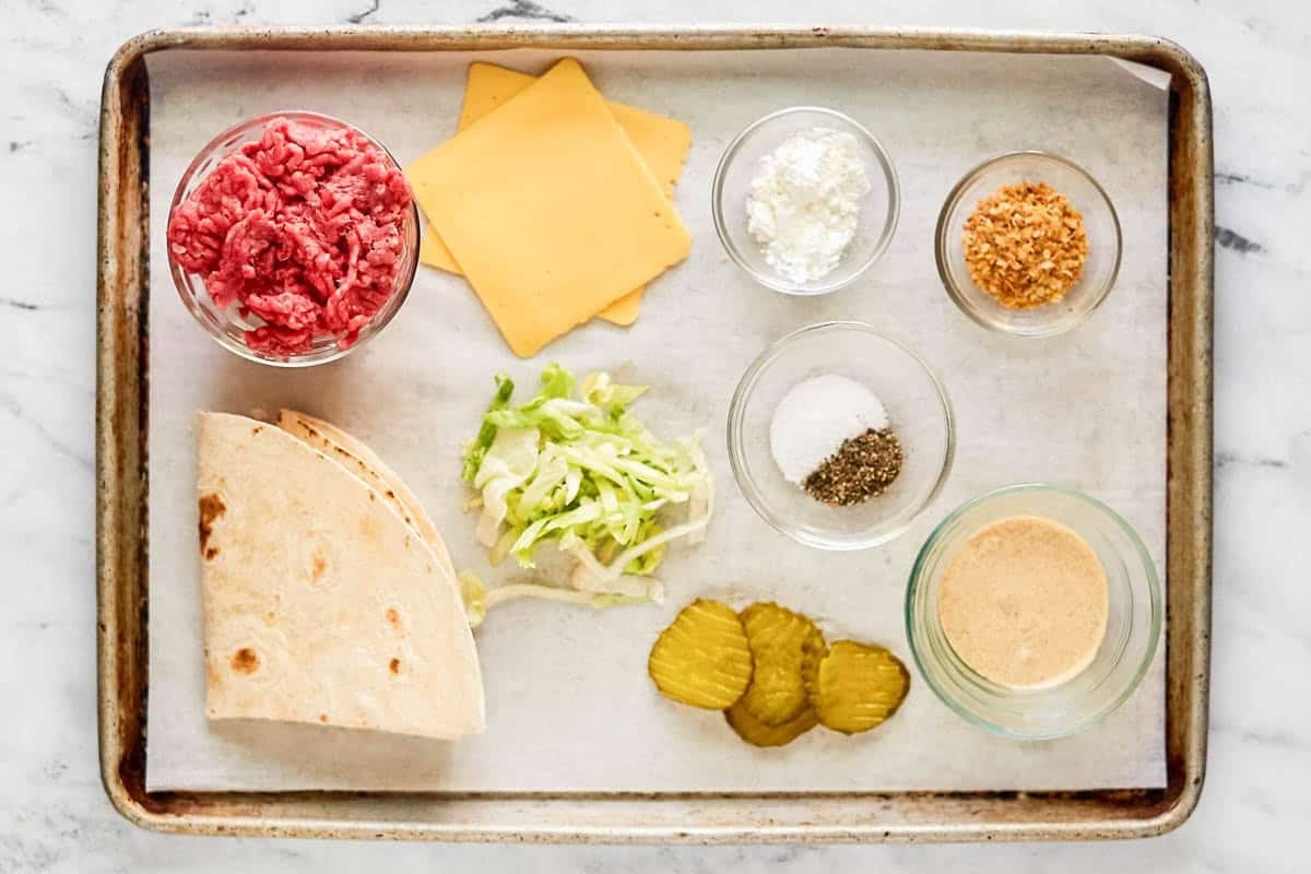 Ground beef, lettuce, pickles, onions, cheese slices, tortillas, and special sauce.