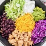 Loaded Mexican chicken rice bowl and a fork on a napkin beside it.
