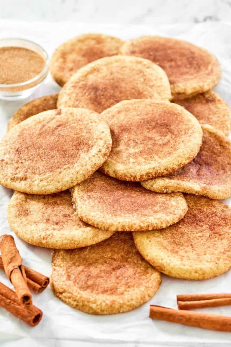 Soft cinnamon sugar cookies piled on parchment paper.
