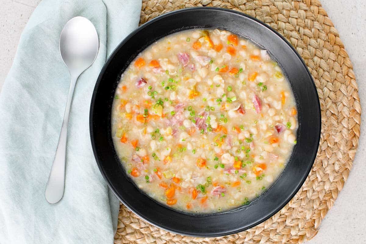 Soup with navy beans and vegetables made with a ham hock.