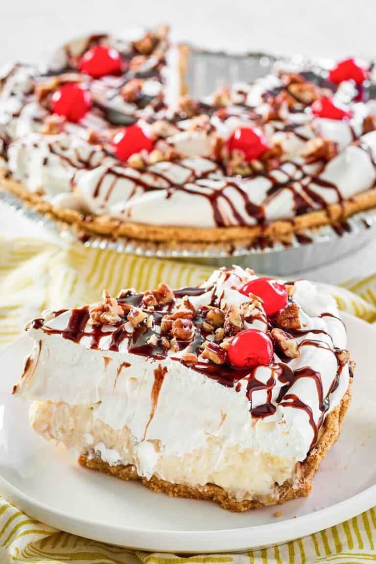Whipped cream, cherries, pecans, and fudge topped banana pineapple pie.
