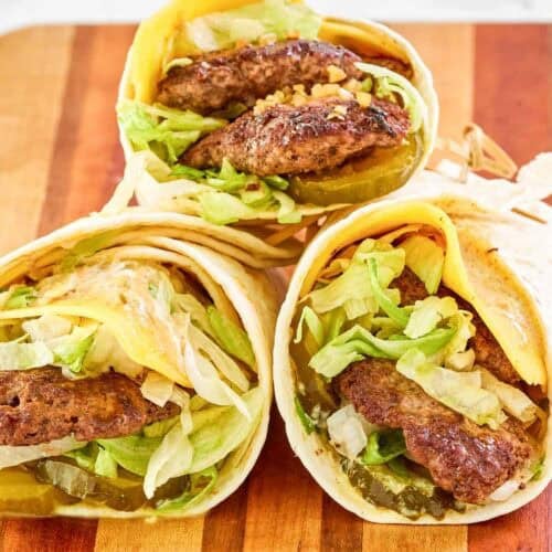 Wraps with ground beef patties and burger toppings.