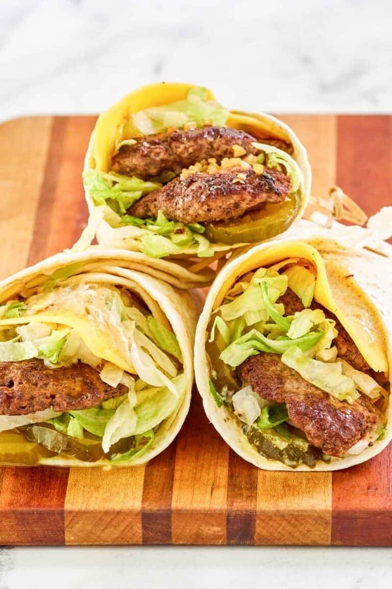 Wraps with ground beef patties and burger toppings.