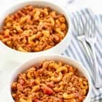 Chili mac and cheese in bowls on a marble surface.