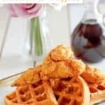 Copycat Grand Lux Cafe chicken and waffles served with syrup.