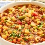 A bowl of hamburger soup with pasta, potatoes, and vegetables.