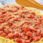 Hot dog tomato sauce over spaghetti noodles.
