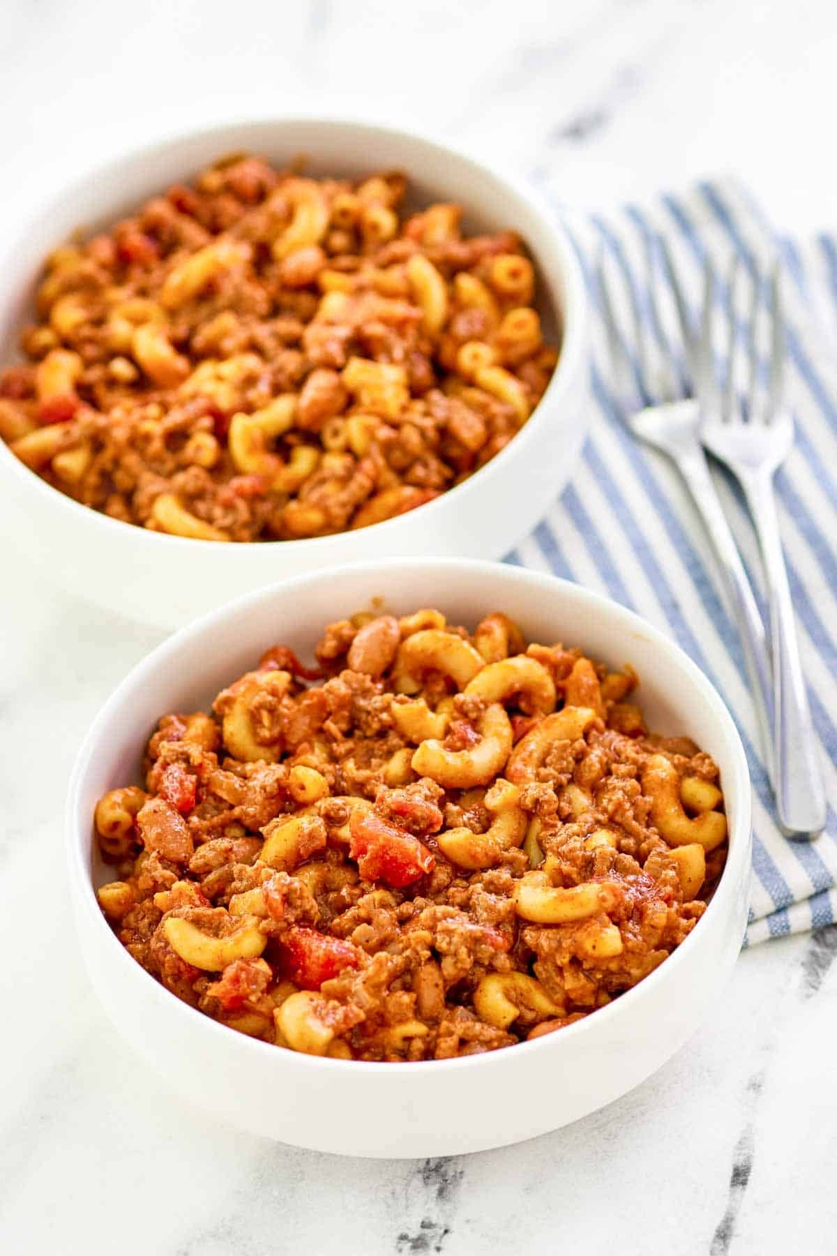 Macaroni with chili and cheese served in bowls.
