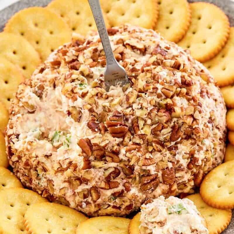 Pecan coated deviled ham cream cheese ball with crackers.
