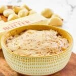 A bowl of copycat Benihana garlic butter, garlic cloves, and a stick of butter.