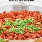 Copycat La Cocina chili Colorado con carne in a large stainless steel skillet.