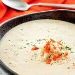 A bowl of homemade Charleston she crab soup topped with crab meat, crab roe, and parsley.