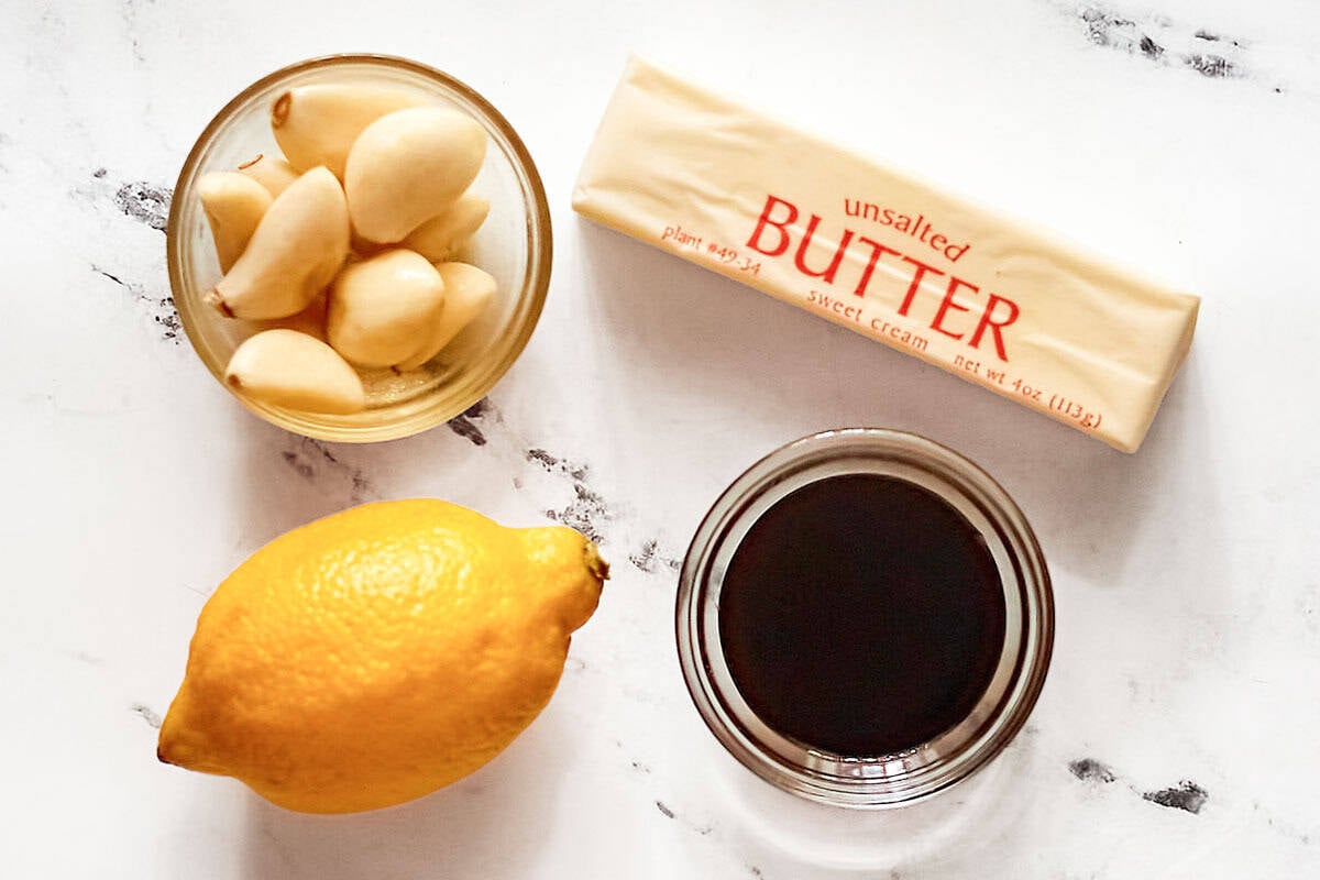 Unsalted butter, garlic cloves, soy sauce, and a lemon.