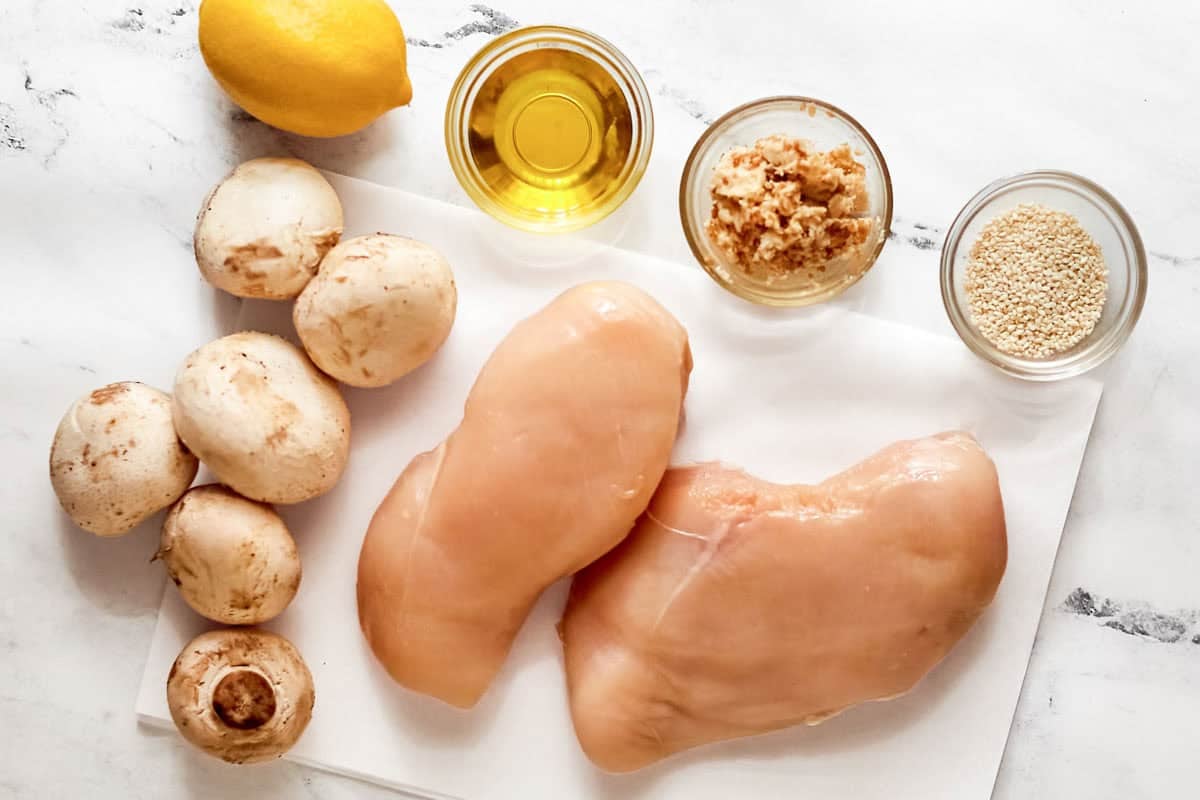 Chicken breasts, mushrooms, oil, salt, garlic butter, lemon, and sesame seeds.