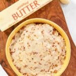 Japanese garlic butter in a bowl, a stick of butter, and garlic cloves.