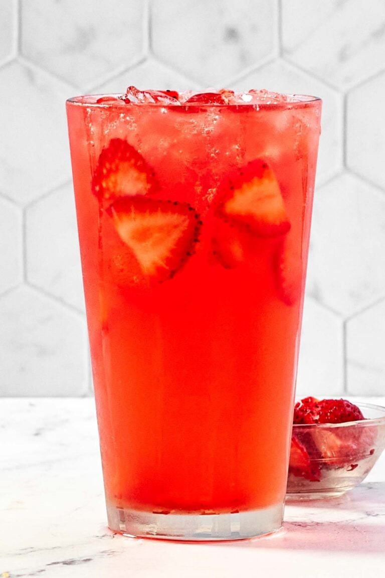Refreshing watermelon strawberry lemonade drink in a tall glass.