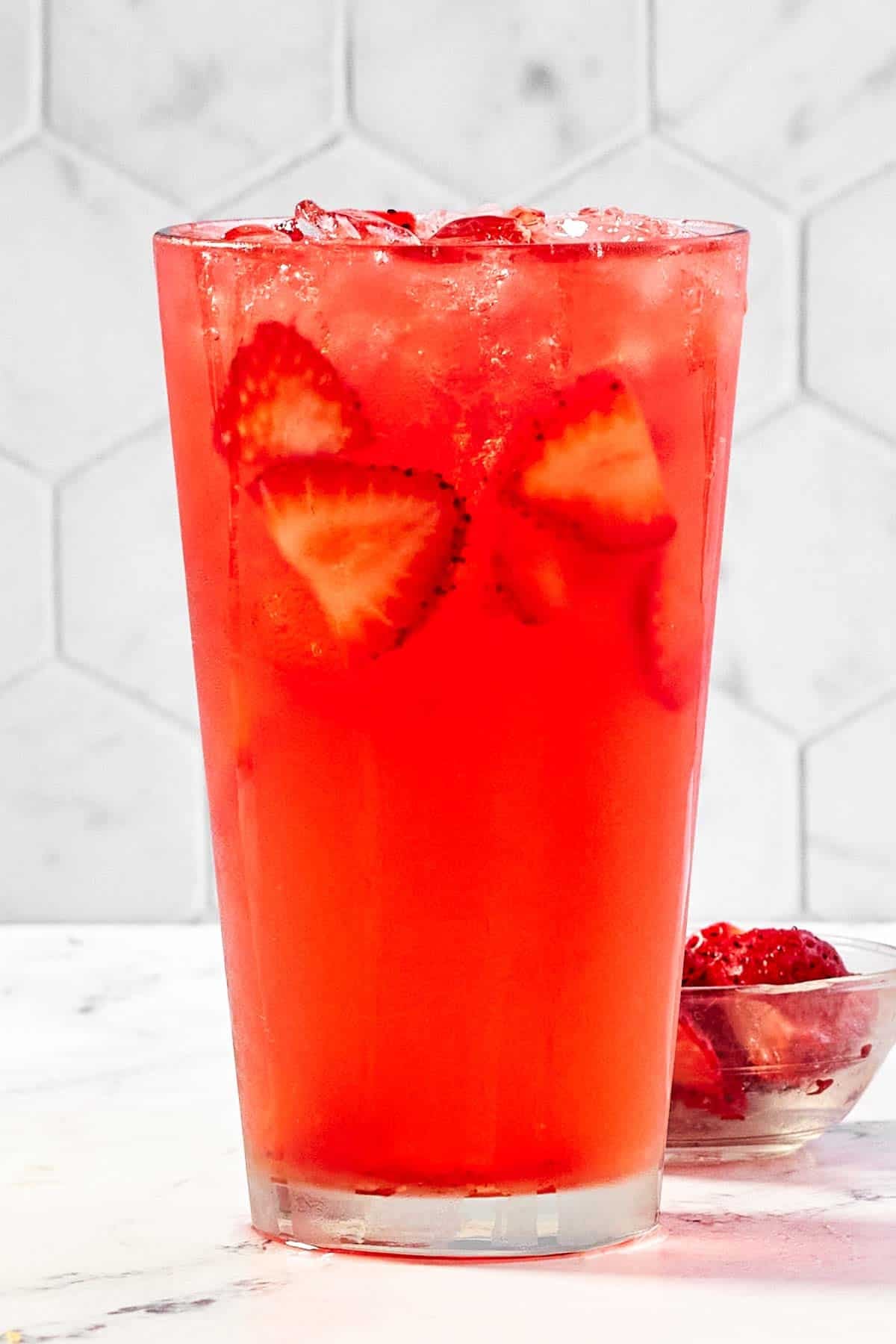 Refreshing watermelon strawberry lemonade drink in a tall glass.